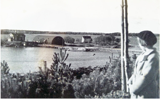 Näkymä Kotkasaarille - Ouritsaarillle 1937. Talo on alunperin kalkkiuunin hoitajan asunto ja halli on Janssonin rakentama ja sitä käytti myös Pettersson. Kuvan on ottanut Christel Kamprad kävelyretkellä tyttärensä Armin kanssa 1937. Armi Kamprad avioitui Matti Wariksen kanssa ja heidän veneensä Catharina II (ensimmäinen Swan 36) on telakoitu vuodesta 1976 lähtien Ourit-saarella. Kuva: Lindgren-arkisto, kuvaaja Cristel Kamprad. 